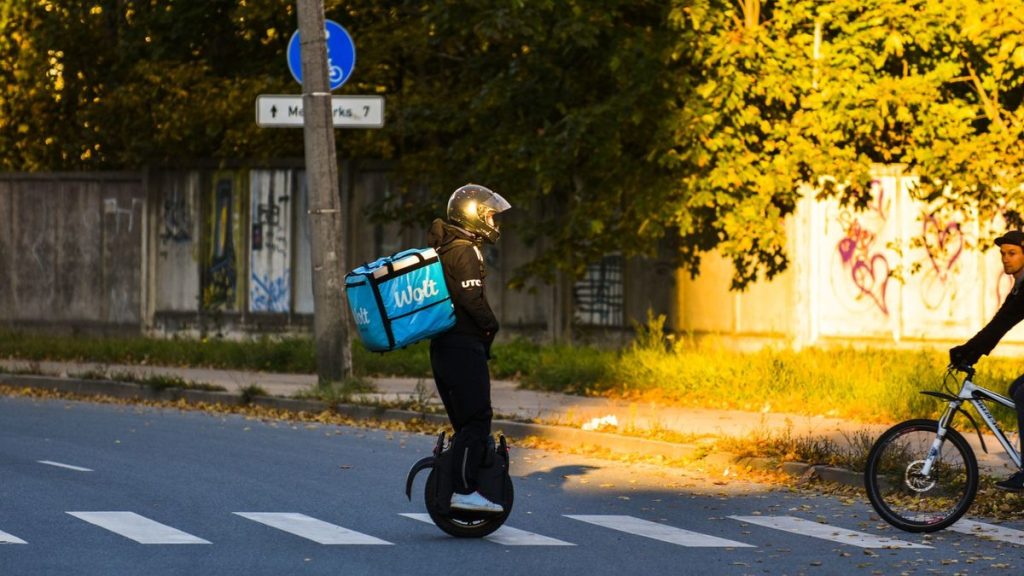Person crossing a street on an electric unicycle