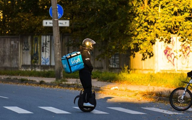 Person crossing a street on an electric unicycle