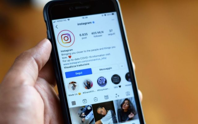 Person holding a smartphone showing an Instagram profile