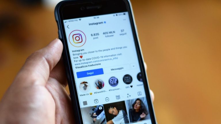 Person holding a smartphone showing an Instagram profile