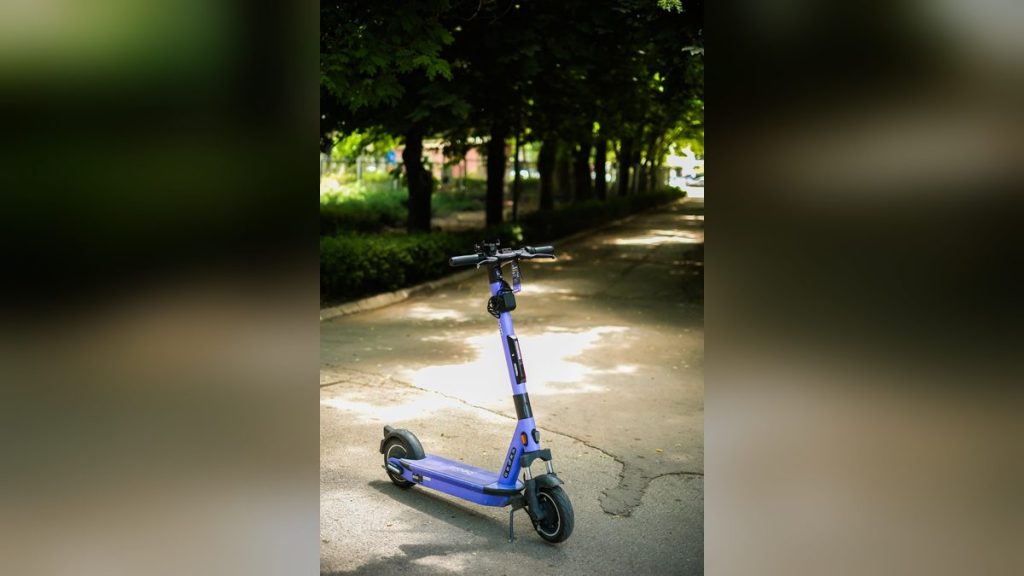 Purple electric scooter on a shaded park path