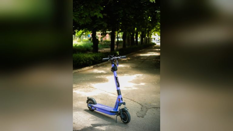 Purple electric scooter on a shaded park path