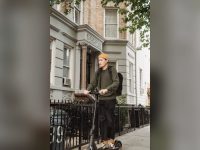 Rider in a yellow sweater on an e-scooter on a quiet street