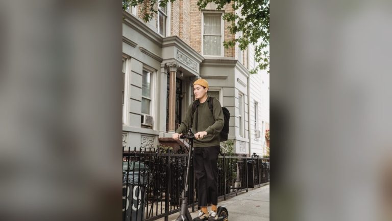 Rider in a yellow sweater on an e-scooter on a quiet street