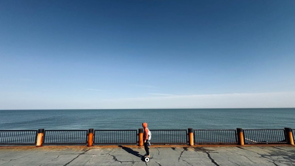 Rider on a hoverboard along the seafront