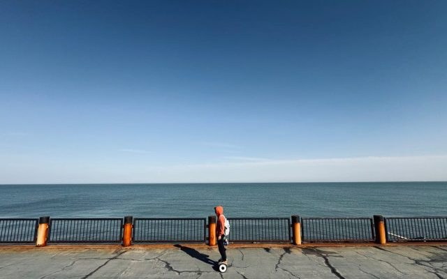 Rider on a hoverboard along the seafront