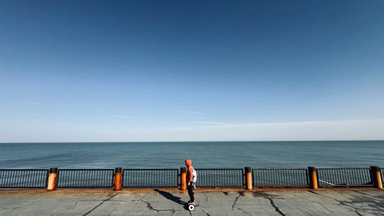 Rider on a hoverboard along the seafront