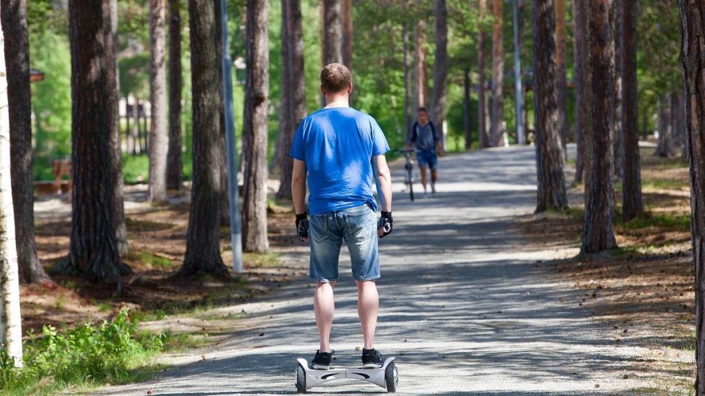 Rider on a self-balancing scooter along a waterfront promenade