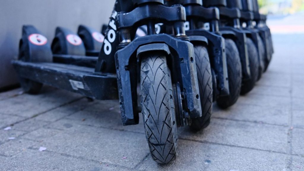 Row of parked electric scooters, close-up of the wheels