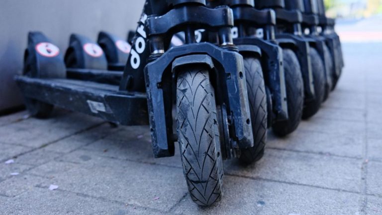 Row of parked electric scooters, close-up of the wheels