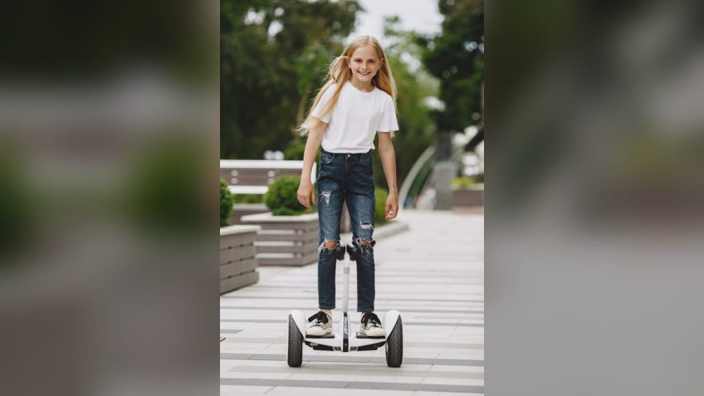 Smiling girl riding a self-balancing scooter