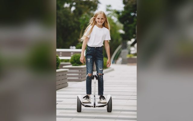 Smiling girl riding a self-balancing scooter
