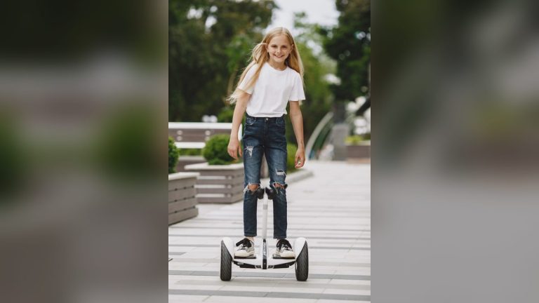 Smiling girl riding a self-balancing scooter