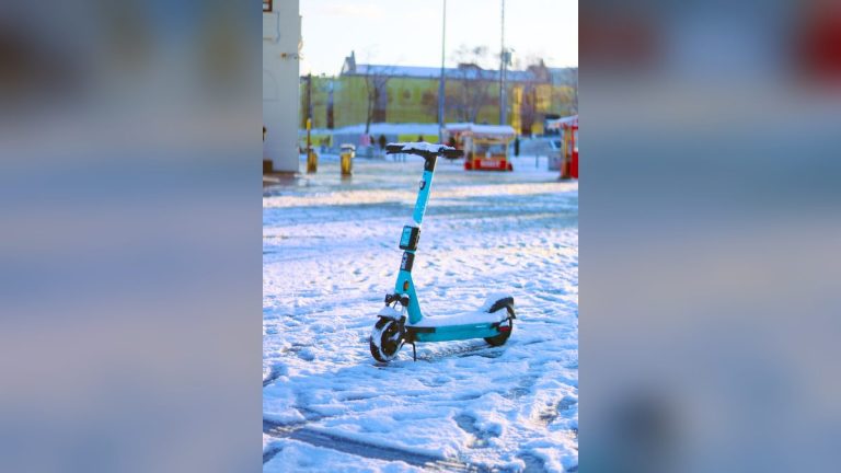 Teal electric scooter on a snowy street