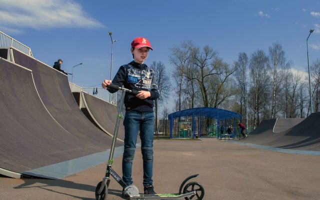 Teenager in a skate park with a kick scooter