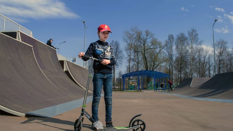 Teenager in a skate park with a kick scooter