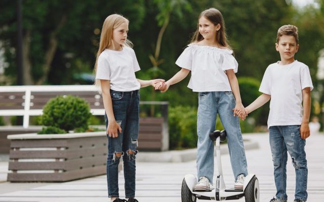 Three children, one on a self-balancing scooter