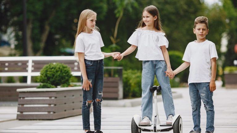 Three children, one on a self-balancing scooter