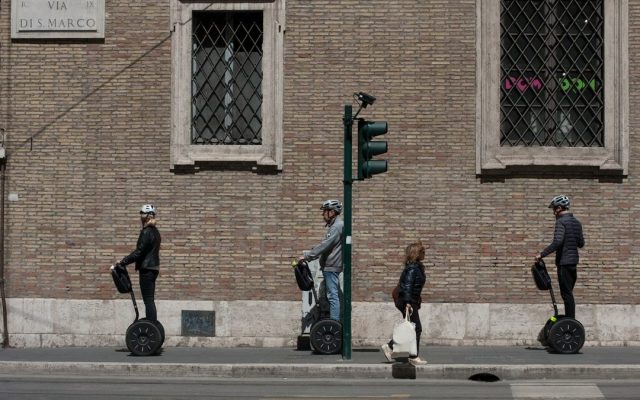 Three people riding hoverboards