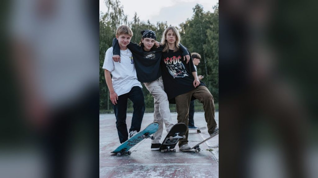 Three teenage skateboarders in a park