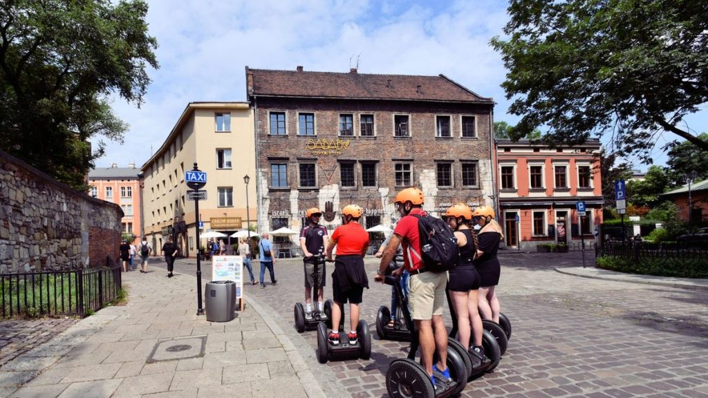 Tourists riding self-balancing scooters on a cobblestone street