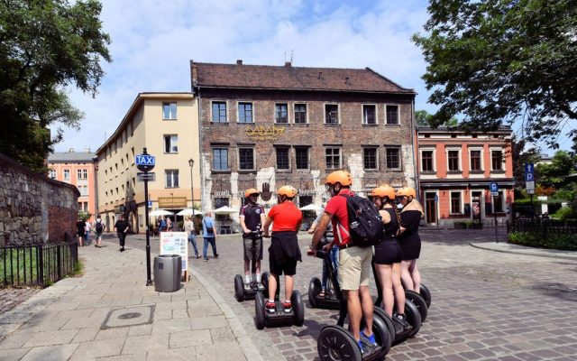 Tourists riding self-balancing scooters on a cobblestone street