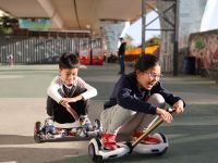 Two children riding hoverboards in a skate park