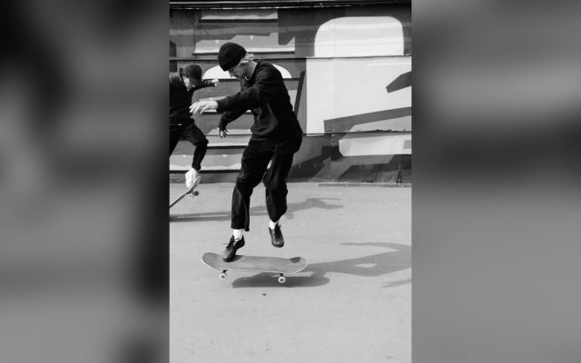 Two skateboarders performing tricks, monochrome