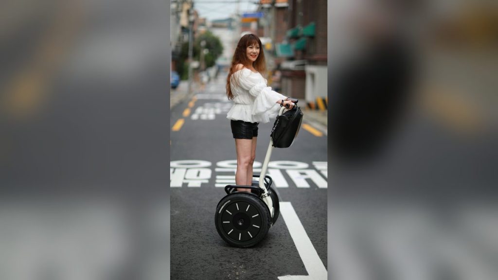 Woman riding a self-balancing scooter on a city street