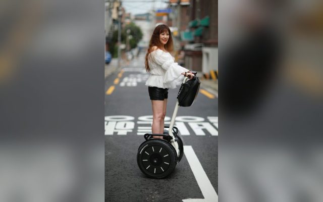 Woman riding a self-balancing scooter on a city street