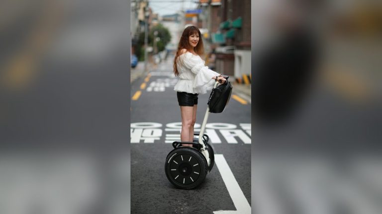 Woman riding a self-balancing scooter on a city street