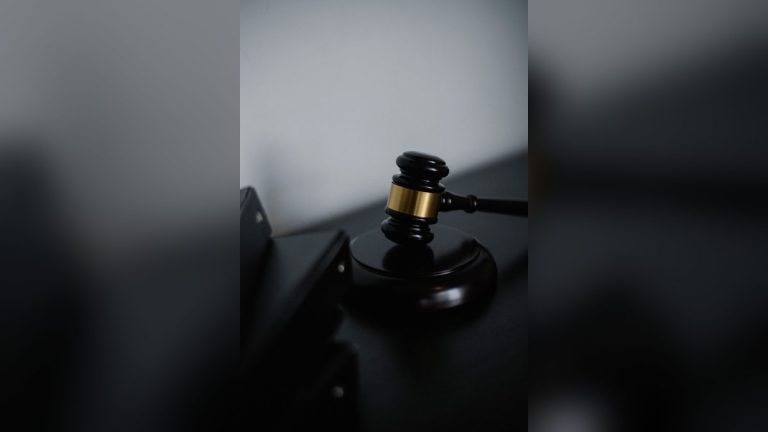 Wooden gavel on a table near folders