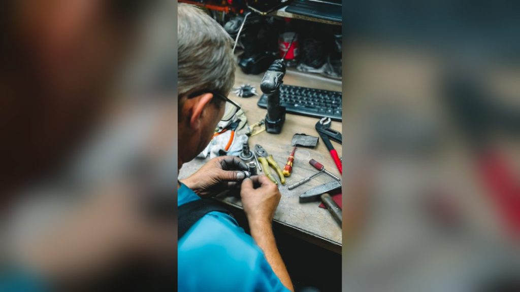 Worker repairing at a cluttered workshop desk
