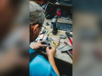 Worker repairing at a cluttered workshop desk
