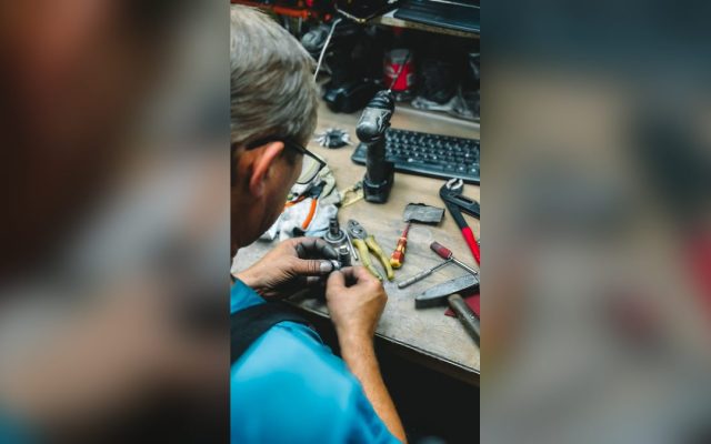 Worker repairing at a cluttered workshop desk