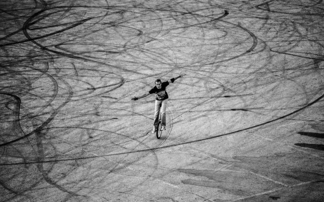 Young man performing freestyle unicycle tricks