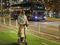 Young woman riding a scooter on a city street at night