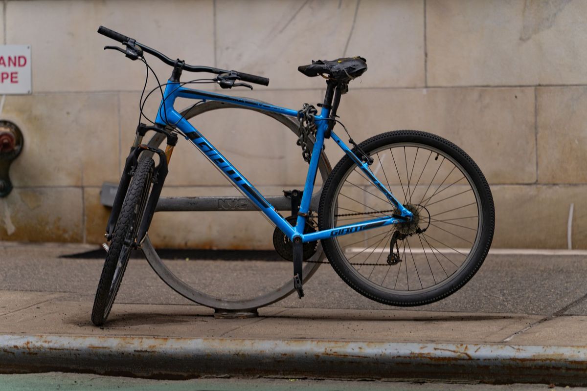 A parked blue bicycle on a city sidewalk in New York