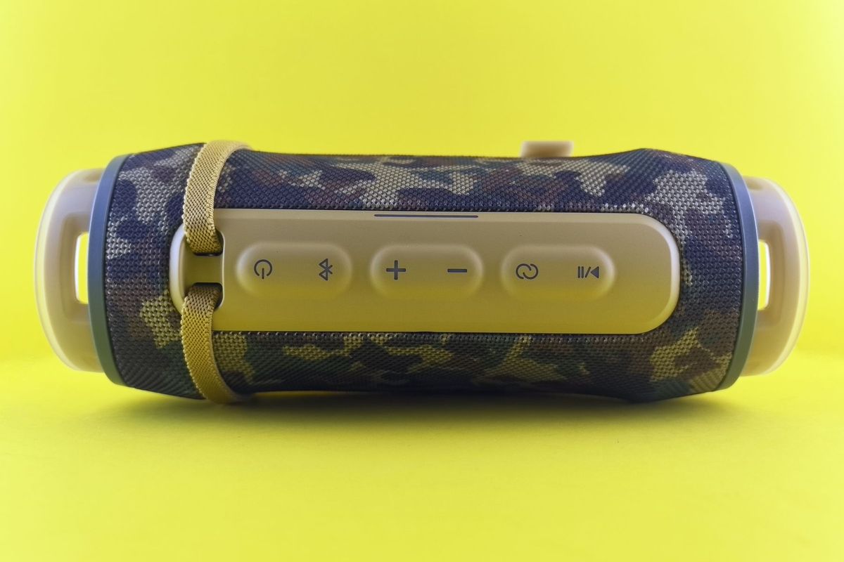 A stylish portable Bluetooth speaker with a camouflage design on a vibrant yellow background