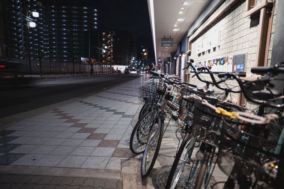 Bicycles parked in a vibrant Osaka street at night