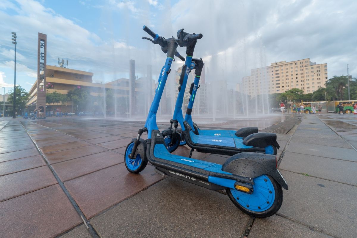 Blue electric scooters on a rainy plaza in Belo Horizonte, Brasil