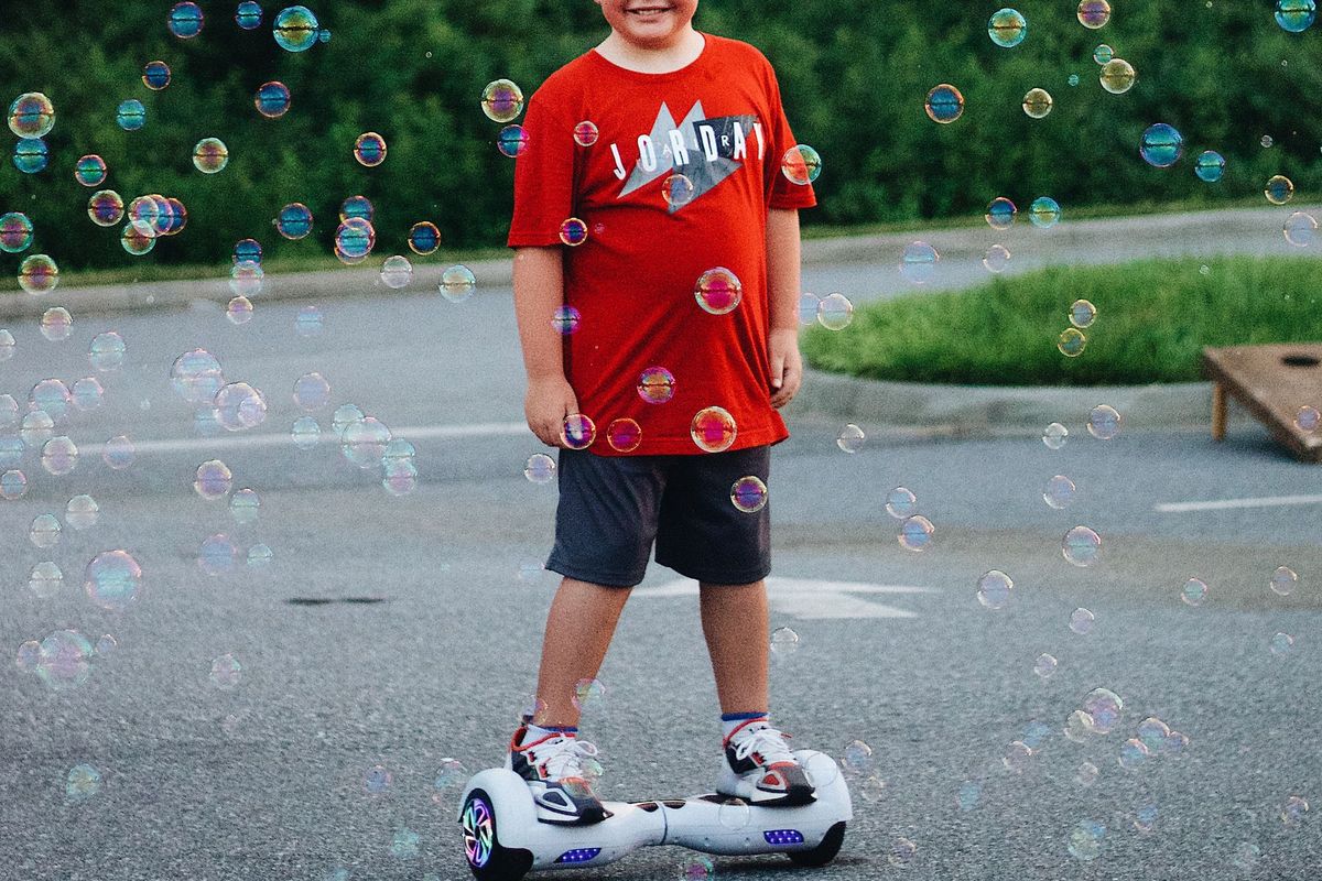 Child standing on a white light-up hoverboard