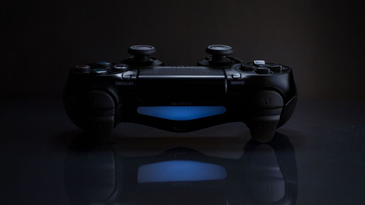 Close-up of a gaming controller with a soft blue light in a dark setting