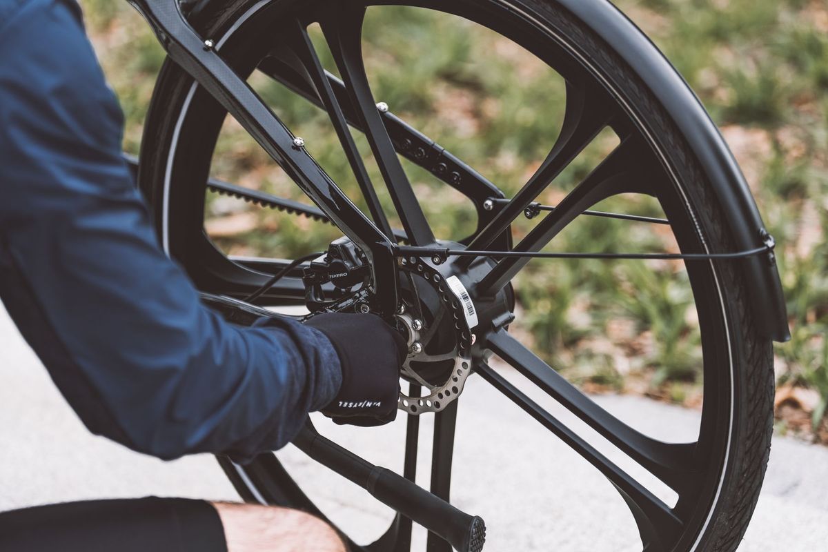 Close-up of a man fixing a bicycle wheel outdoors