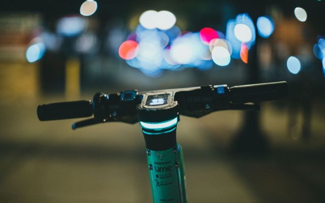 Close-up of electric scooter handlebars at night with a beautiful bokeh background