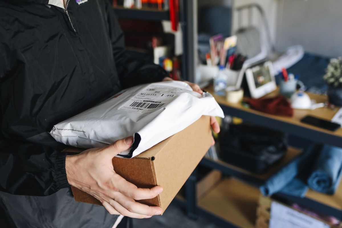 Close-up of hands holding cardboard and plastic packages