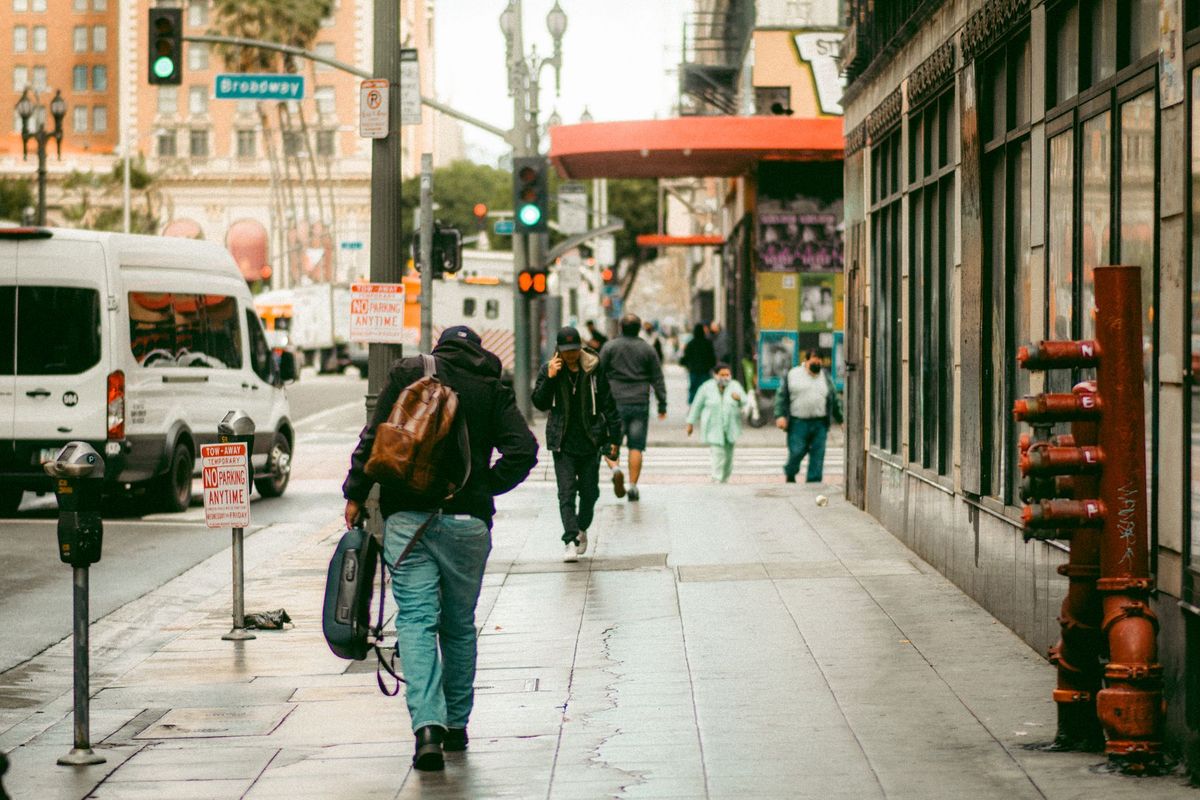 Commuters walk along wet sidewalks in downtown Los Angeles after rain