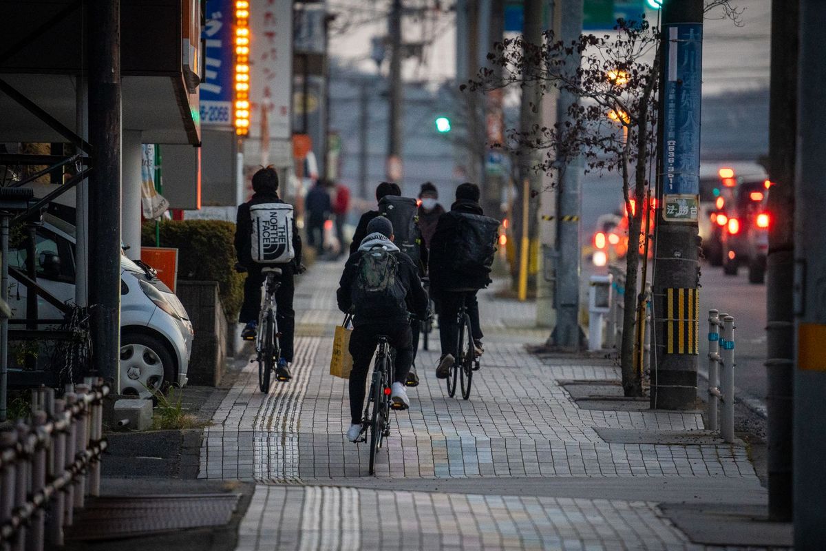 Cyclists commute through the city street at dusk