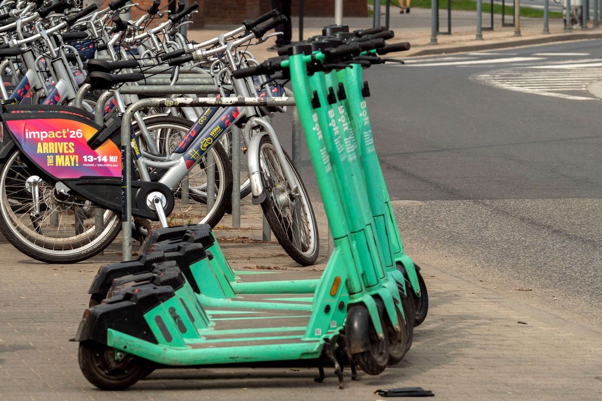 E-scooters and bicycles parked on a street in Wrocław, Poland