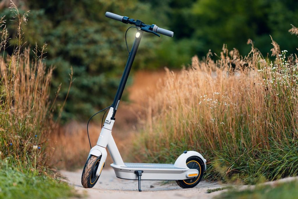 Eco-friendly electric scooter on a scenic rural path between tall grass and greenery